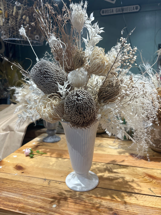 Tall white vase with dried floral arrangement